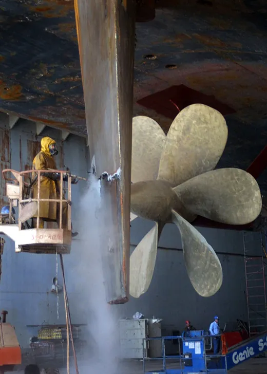 Ship propeller and hull being cleaned before coating maintenance