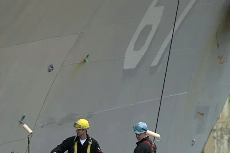 Sailors painting a ship hull, checked against the marine coating technical data sheet