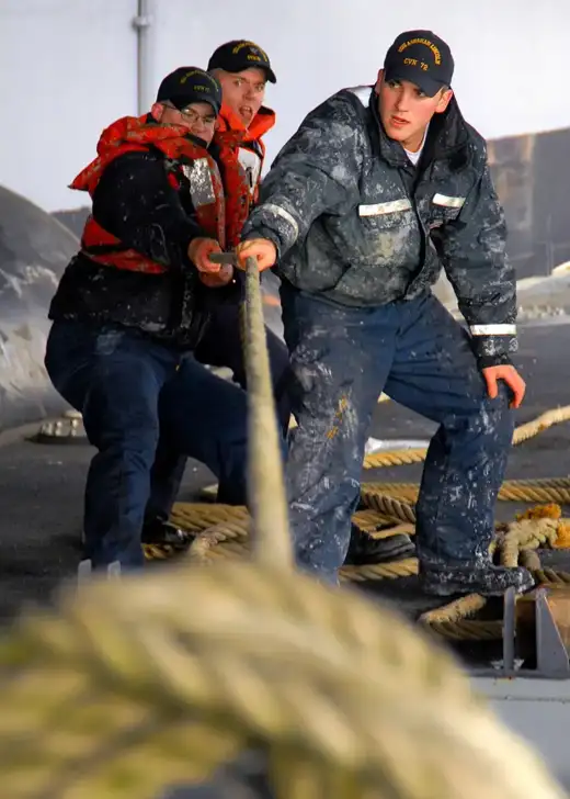 Paint team on a painting barge applying coatings to a ship side