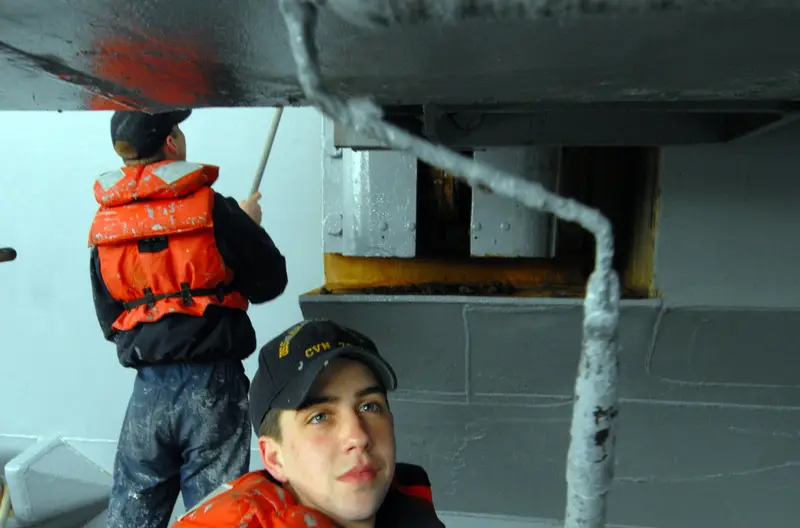 Marine epoxy vs polyurethane: crew rolling a polyurethane topcoat onto a steel ship surface